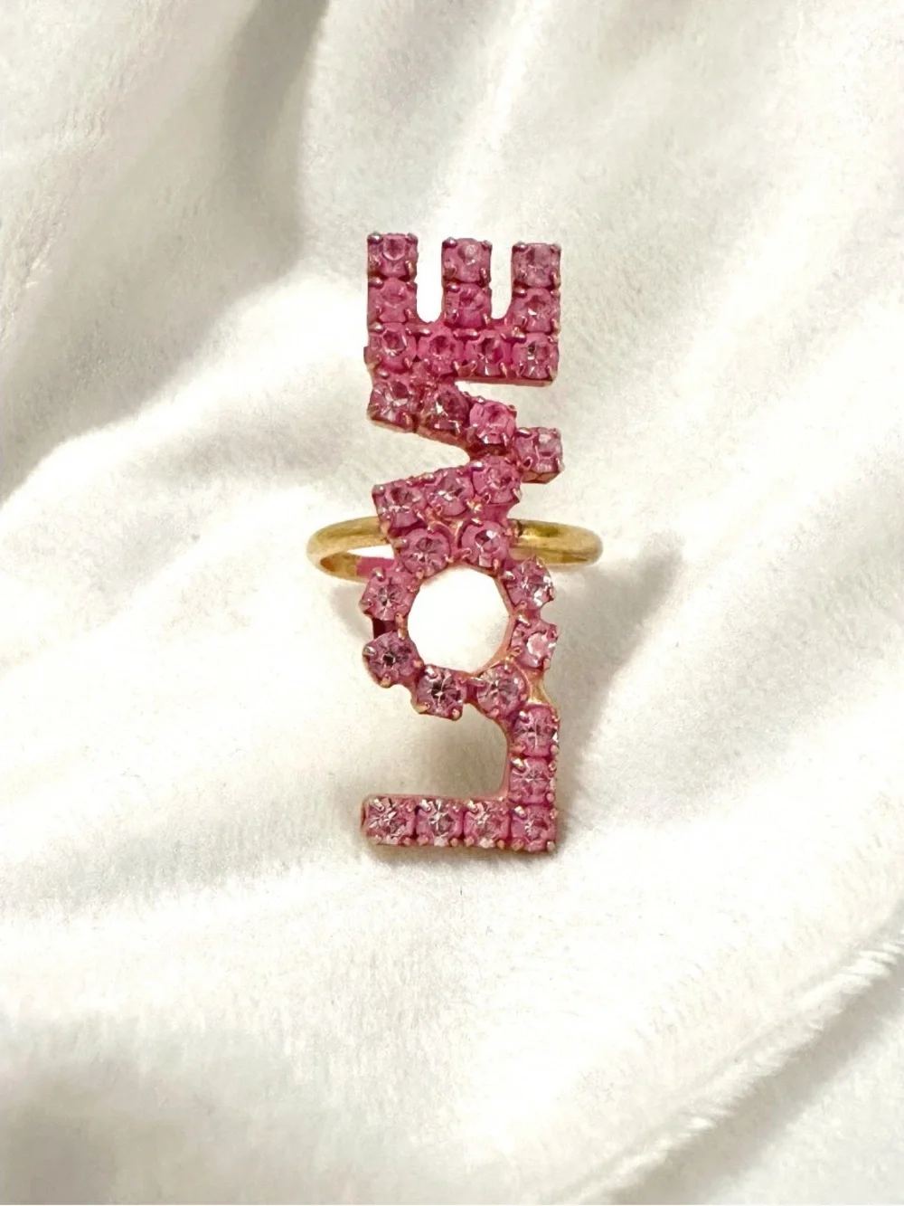 Tova LOVE statement Ring featuring pink crystals set in a gold-tone band